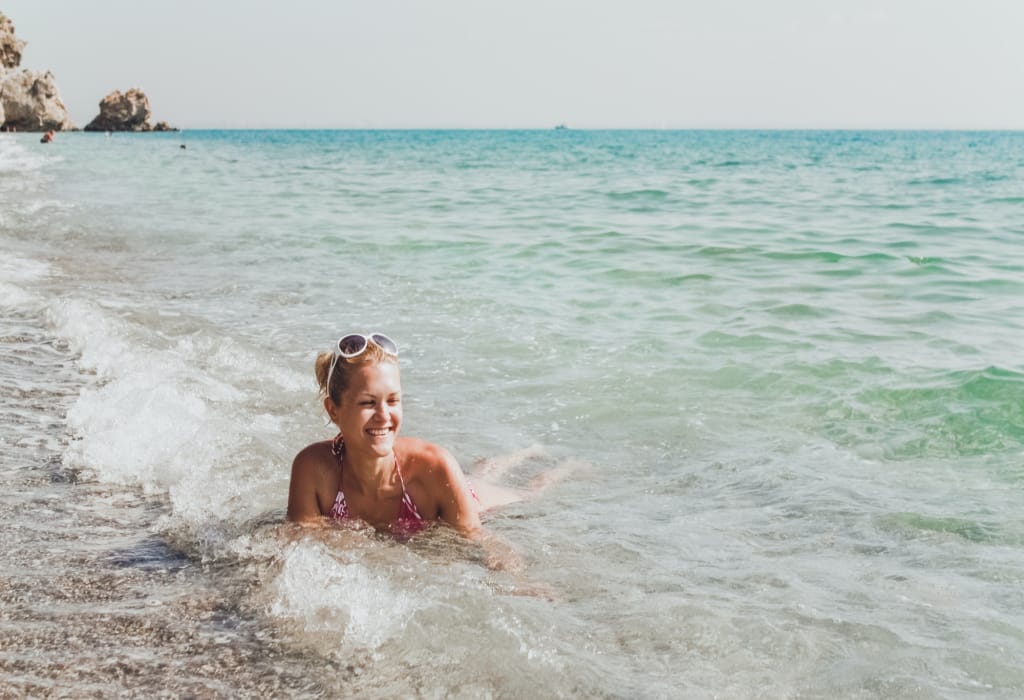 a-young-woman-lies-on-the-seashore-and-rejoices-in-the-waves-vacation-and-travel-concept Île Bianca à Hurghada