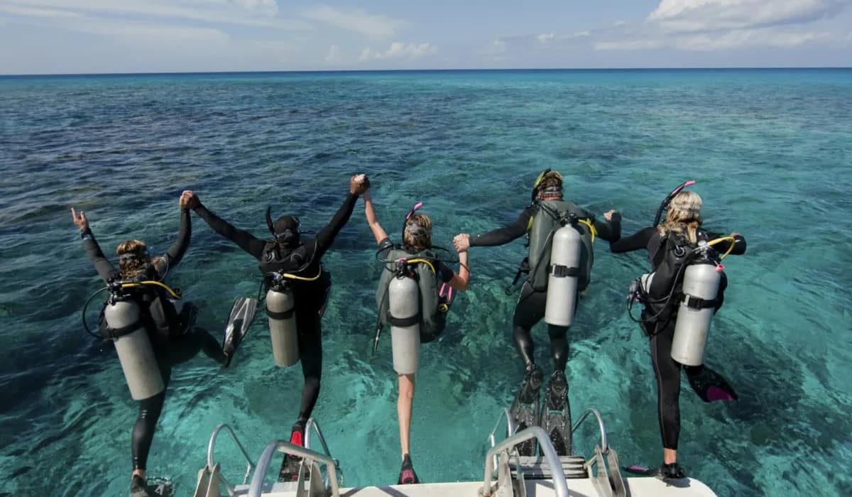 scuba-divers-enter-water-from-boat-via-giant-stride-entry-diving-into-the-water–1536×1025 Hurghada : 2 plongées pour débutants ou excursion snorkeling avec déjeuner